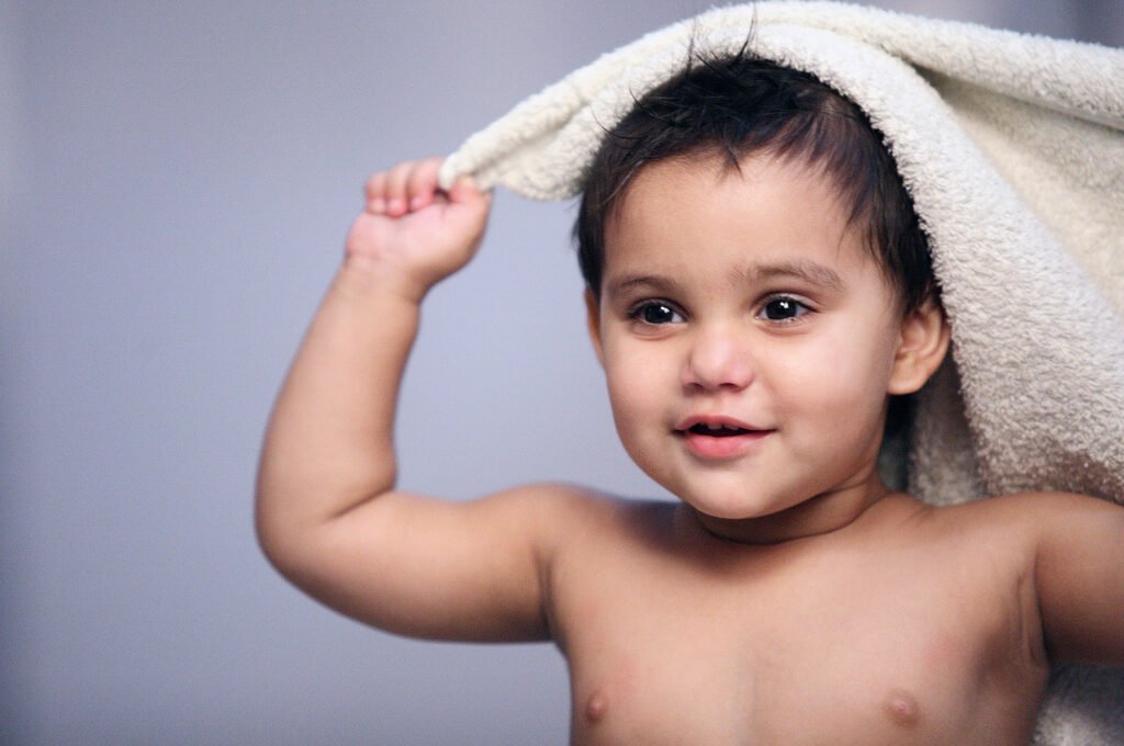 Toddler photography Auckland studio session of smiling baby boy with towel