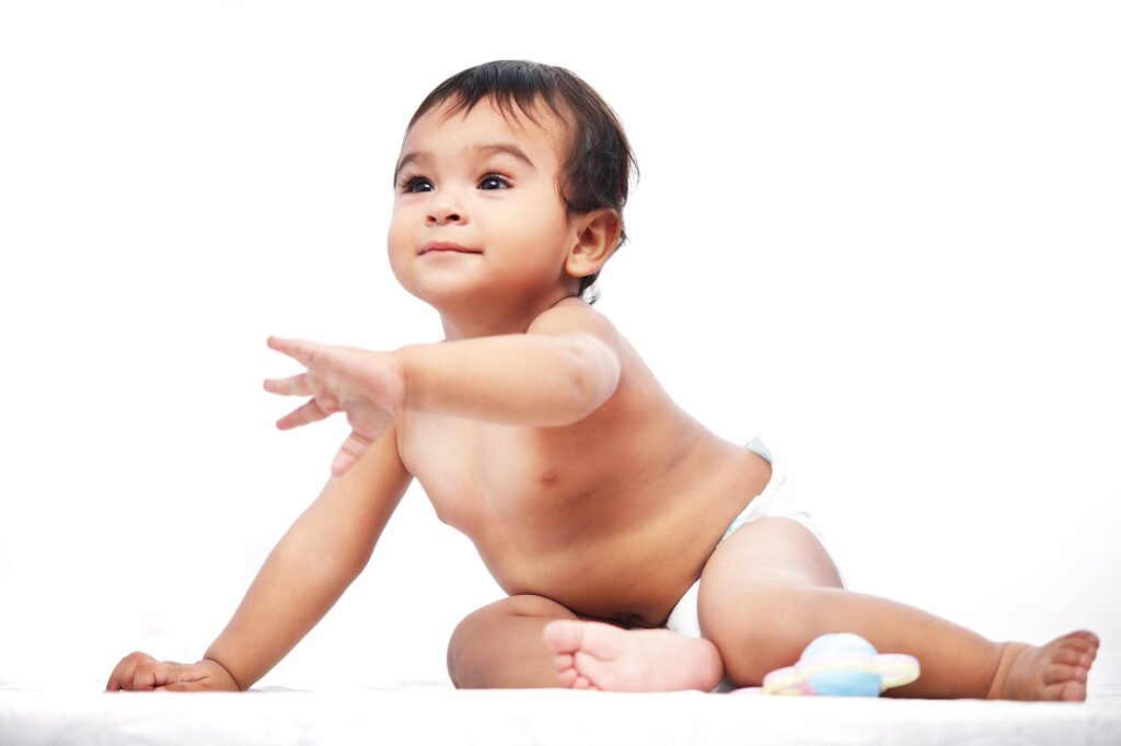 Baby photographer Auckland studio session of cute infant reaching out hand