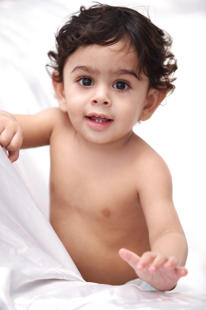Infant photography Auckland studio session of smiling baby with curly hair