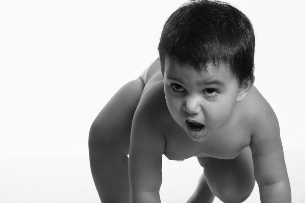 Black and white baby photography Auckland session of toddler crawling with open mouth