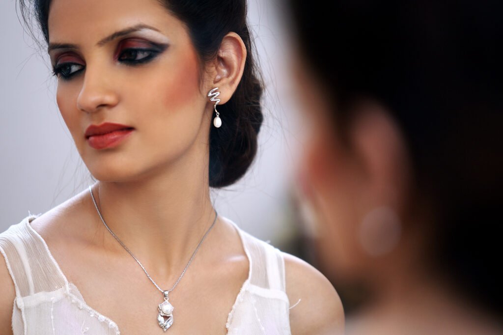 Commercial jewellery photography Auckland of model wearing silver pearl necklace and earrings