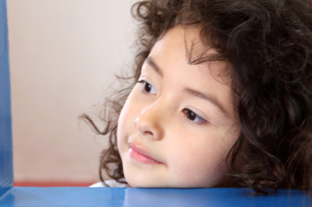 School portrait photography Auckland of little girl with curly hair looking away