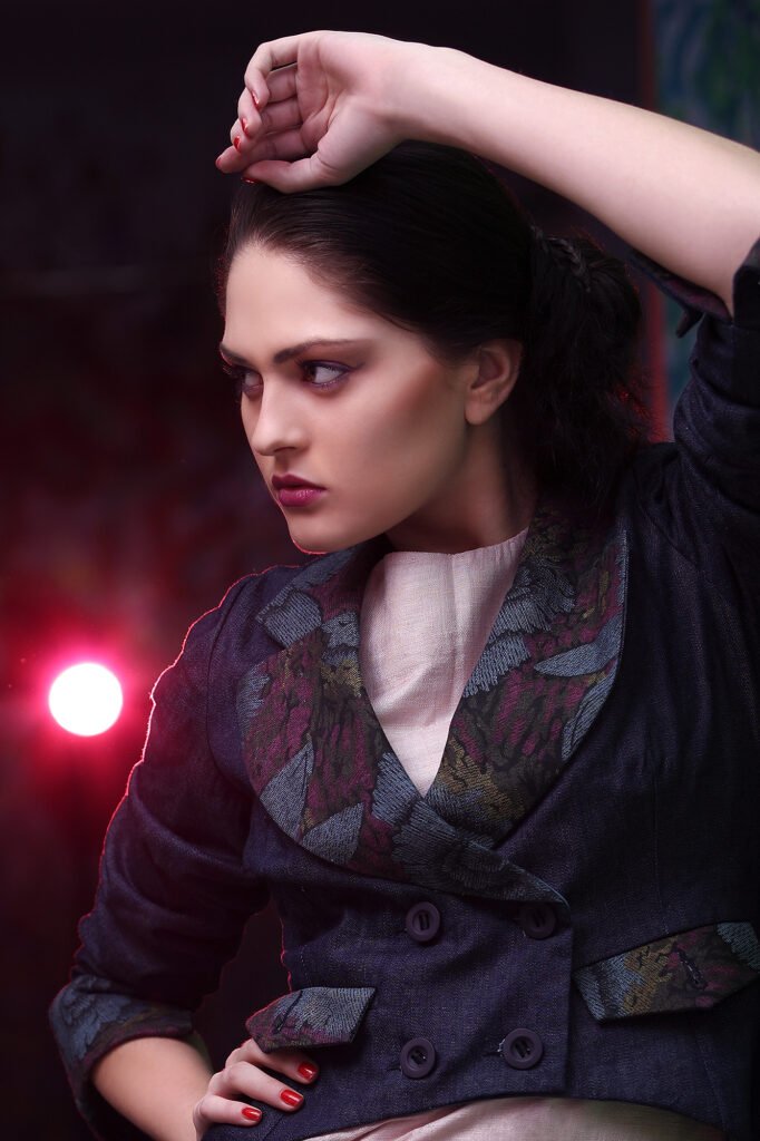 Dramatic studio fashion portrait of a female model with red spotlight illumination by Auckland photographer Jassa Studio