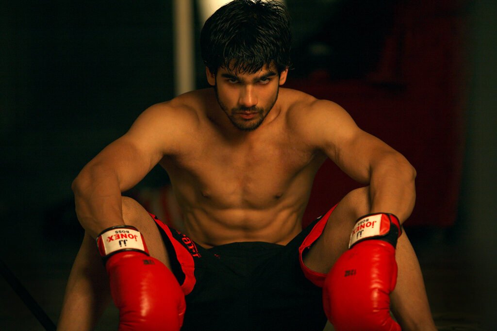 Shirtless male fitness model wearing red boxing gloves in an athletic sports portfolio shoot by Auckland photographer Jassa Studio