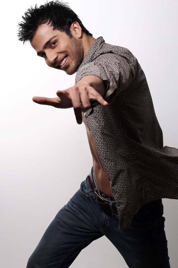 Male fashion model in an unbuttoned shirt posing for a dynamic studio lookbook shoot by Auckland photographer Jassa Studio