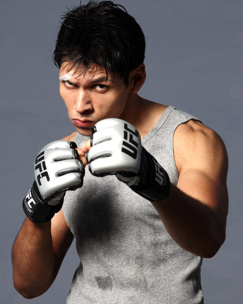 Male fitness model posing with combat training UFC gloves in a dramatic sports action portfolio shoot by Auckland photographer Jassa Studio