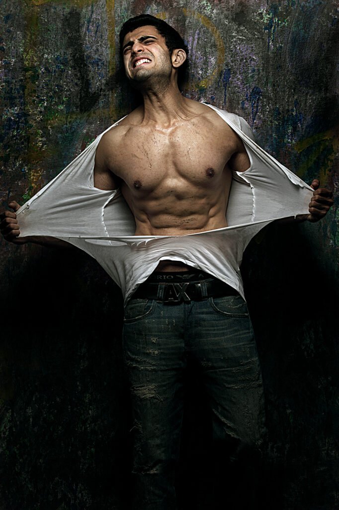 Male fitness model ripping a white shirt in a dramatic athletic portfolio shoot by Auckland photographer Jassa Studio