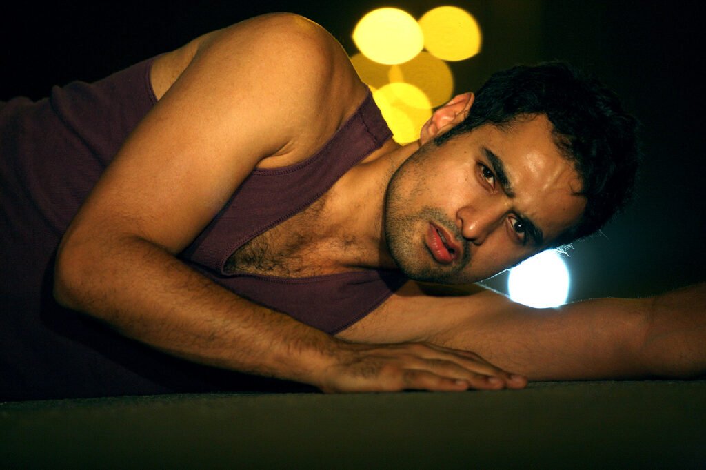 Cinematic low angle male model portrait with city bokeh lights background during a night photoshoot by Auckland photographer Jassa Studio