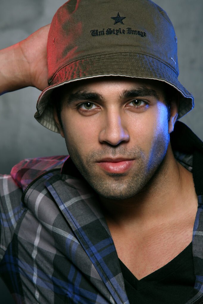 Close up male fashion model wearing a bucket hat and a plaid jacket for a dramatic studio photoshoot by Auckland photographer Jassa Studio